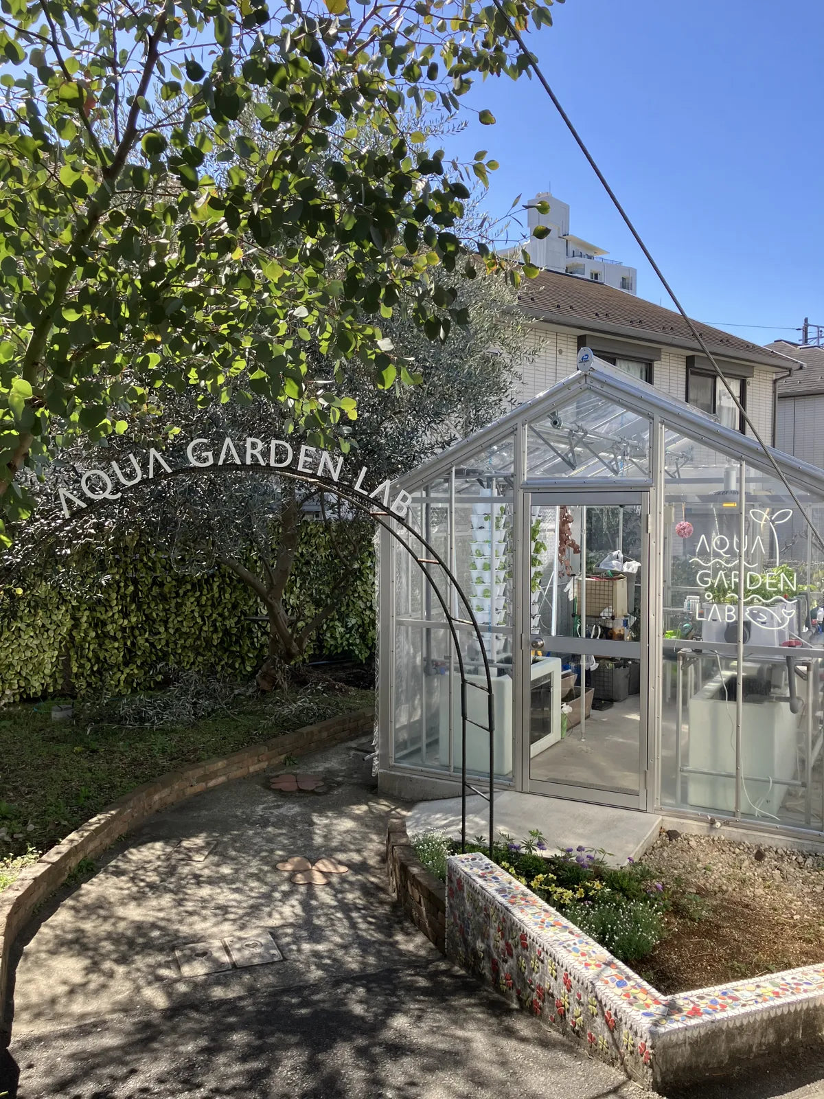 The greenhouse seen from the station garden, with grow towers visible through the glass