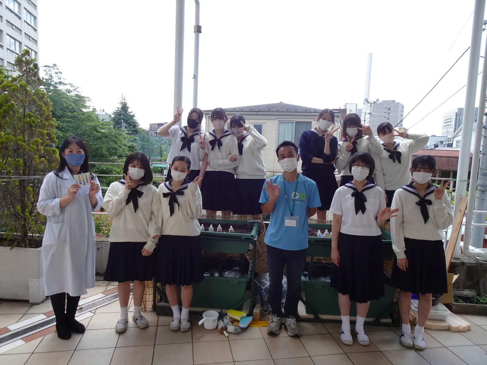 The class, their teacher, and Aquponi staff standing on the terrace beside the systems